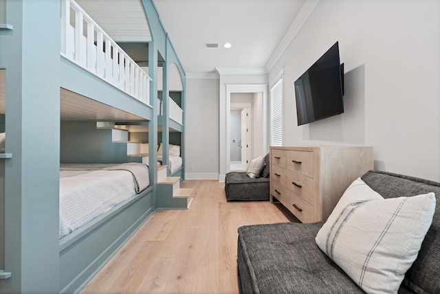 bedroom with ornamental molding and light hardwood / wood-style flooring