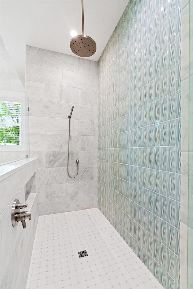 bathroom with tiled shower and tile walls