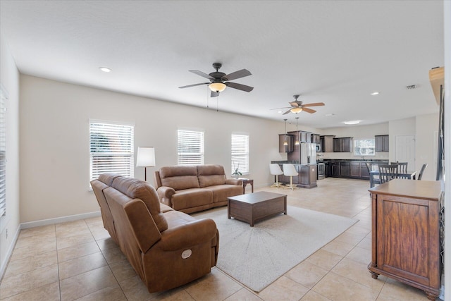 tiled living room with ceiling fan and plenty of natural light