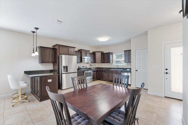 dining space featuring sink and light tile patterned flooring