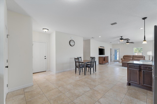 kitchen featuring pendant lighting, ceiling fan, light tile patterned flooring, and dark brown cabinets