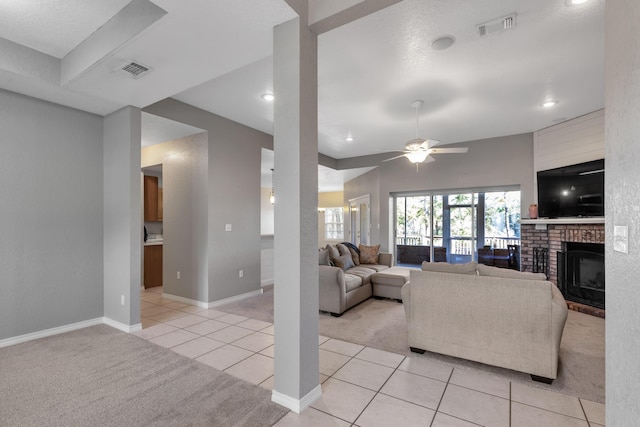 carpeted living room with a brick fireplace and ceiling fan