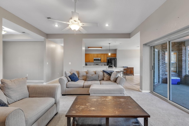 carpeted living room with ceiling fan