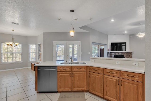 kitchen with a wealth of natural light, sink, stainless steel dishwasher, and a textured ceiling