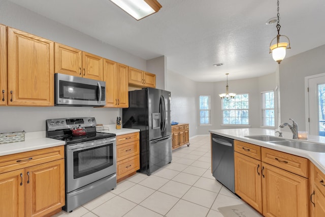 kitchen featuring appliances with stainless steel finishes, sink, light tile patterned floors, a notable chandelier, and hanging light fixtures