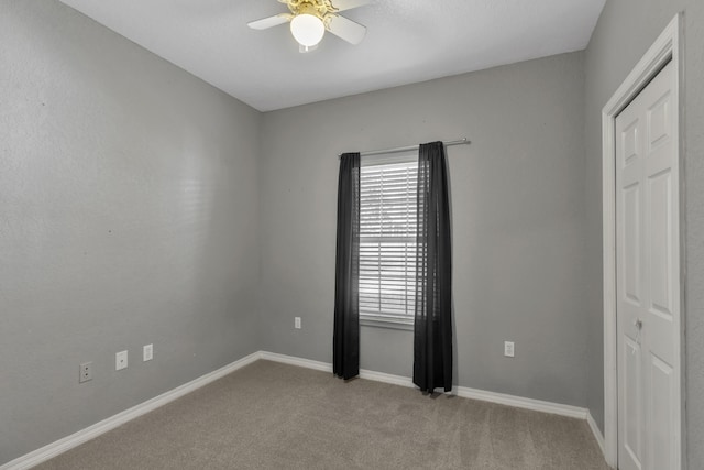 carpeted spare room with ceiling fan