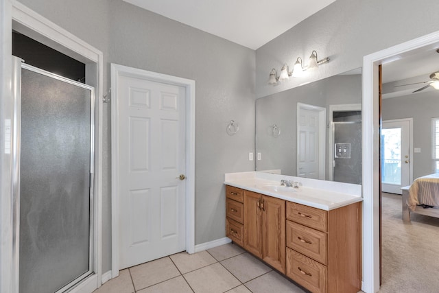 bathroom with ceiling fan, tile patterned flooring, vanity, and walk in shower