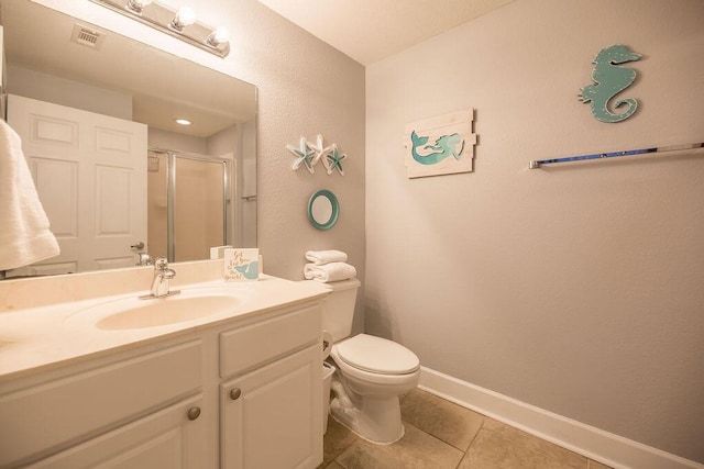 bathroom with tile patterned floors, vanity, toilet, and a shower with door