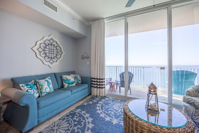 living room with expansive windows, a water view, ceiling fan, and crown molding