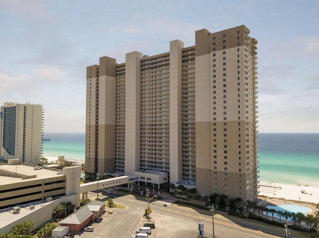 view of building exterior featuring a water view and a view of the beach