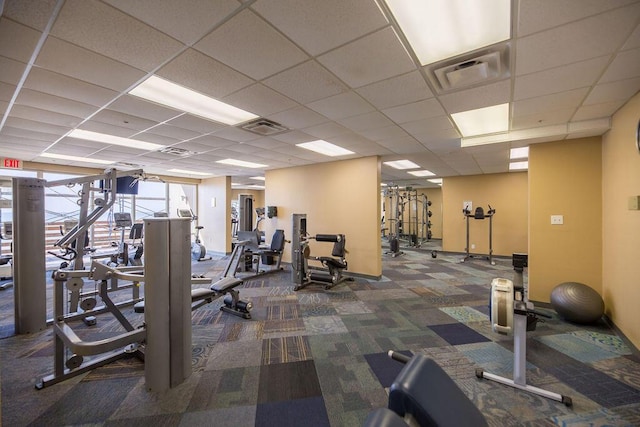 exercise room with carpet flooring and a paneled ceiling