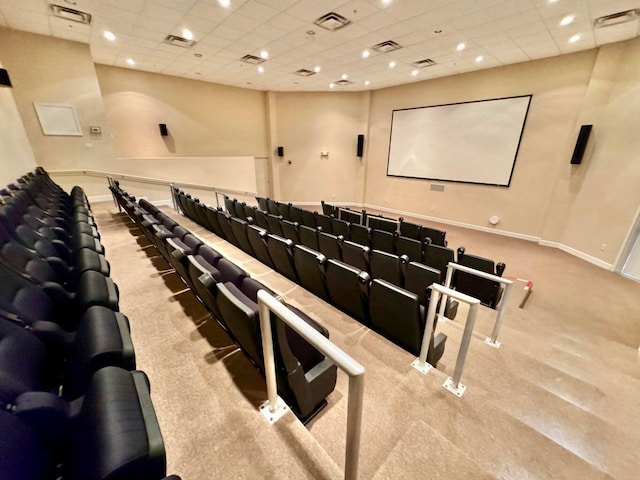 carpeted home theater room with a paneled ceiling