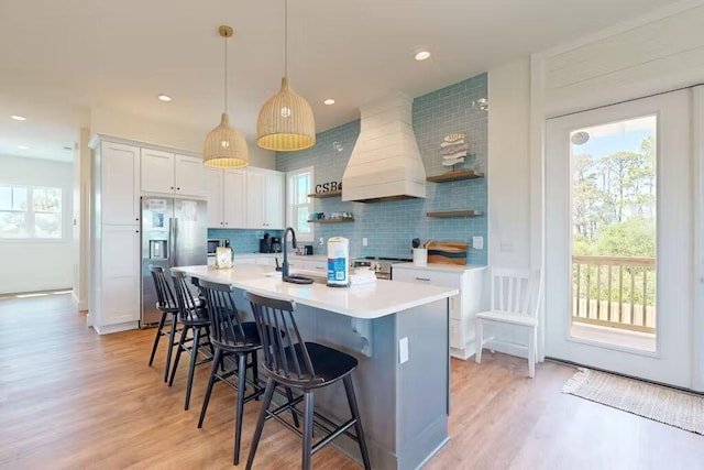 kitchen with stainless steel appliances, white cabinetry, a healthy amount of sunlight, and custom exhaust hood