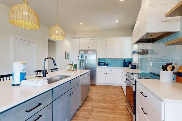 kitchen featuring appliances with stainless steel finishes, gray cabinets, decorative light fixtures, and white cabinetry