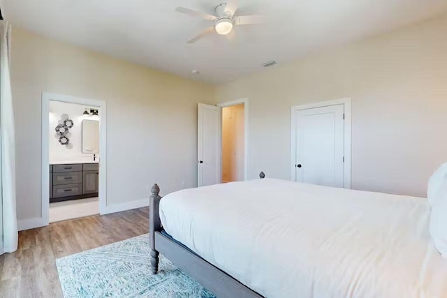 bedroom featuring connected bathroom, a closet, light hardwood / wood-style flooring, and ceiling fan