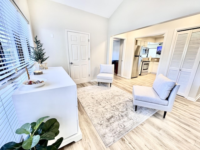 sitting room with light hardwood / wood-style flooring and lofted ceiling