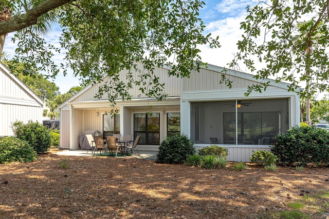 back of property with a sunroom, ceiling fan, and a patio area