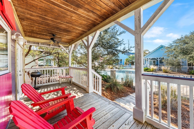 wooden terrace featuring a grill, ceiling fan, a water view, and a porch