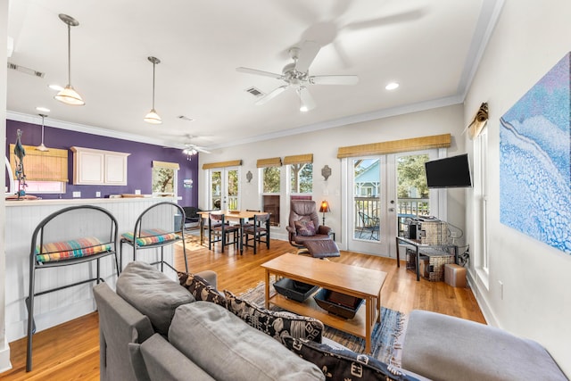 living room with french doors, light hardwood / wood-style floors, ceiling fan, and crown molding