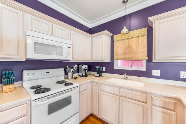 kitchen featuring pendant lighting, white appliances, and sink