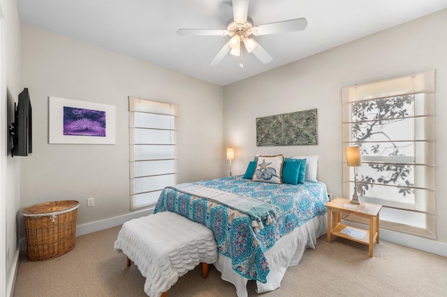 carpeted bedroom featuring multiple windows and ceiling fan