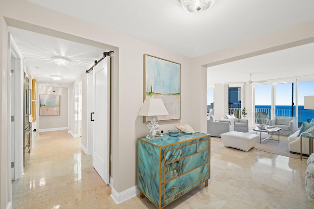 hallway featuring a barn door and a water view