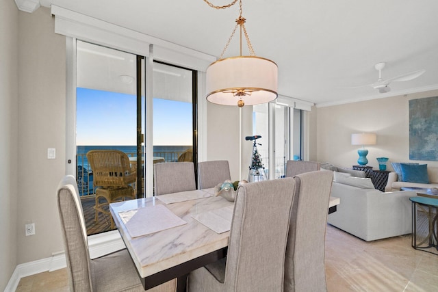 tiled dining room with a water view, ceiling fan, and ornamental molding