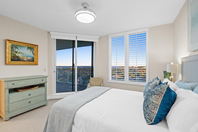 bedroom featuring expansive windows, light colored carpet, and access to outside