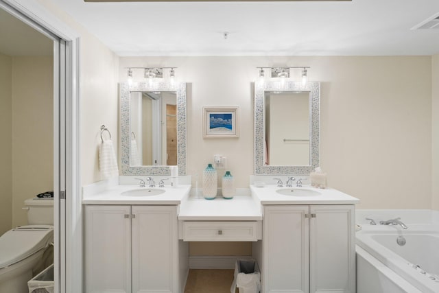 bathroom featuring a bathing tub, vanity, and toilet