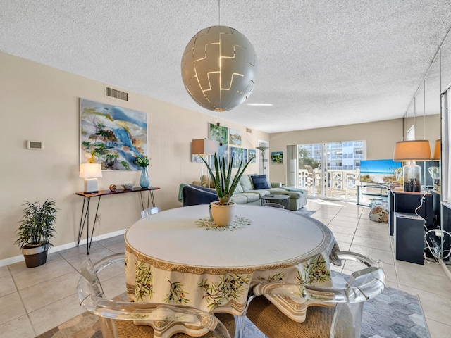 tiled dining area featuring a textured ceiling