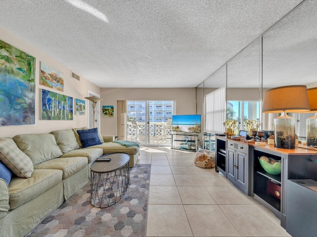 living room featuring a textured ceiling and light tile patterned floors