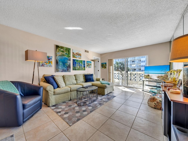 living room featuring a textured ceiling and light tile patterned floors