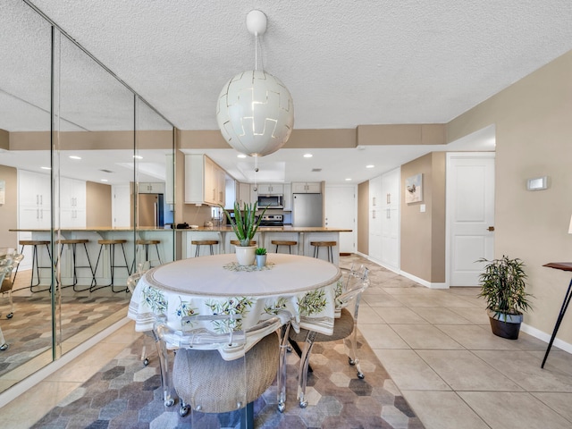 dining room with a textured ceiling and light tile patterned floors