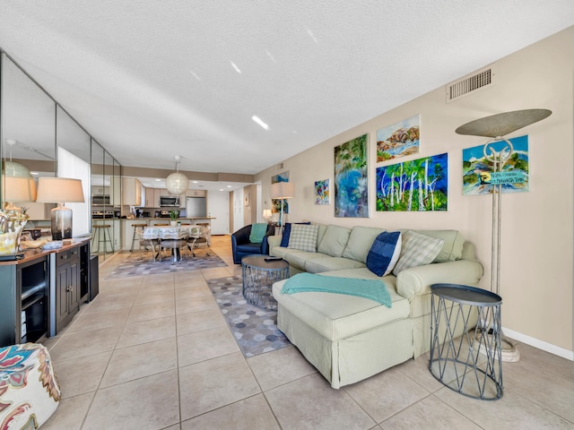 living room featuring a textured ceiling and light tile patterned floors