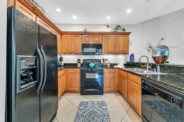 kitchen featuring light tile patterned flooring, sink, dark stone counters, and black appliances