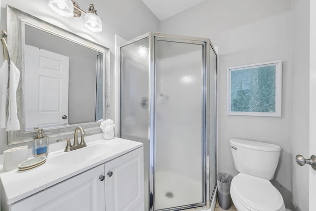 bathroom featuring a shower with door, vanity, and toilet