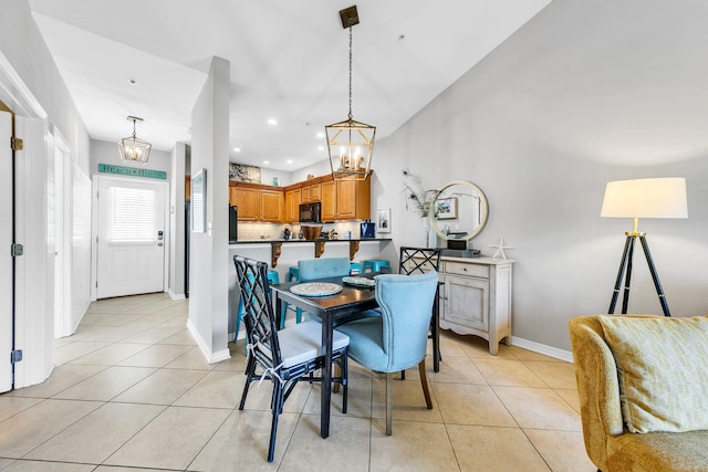 dining area featuring a notable chandelier and light tile patterned flooring