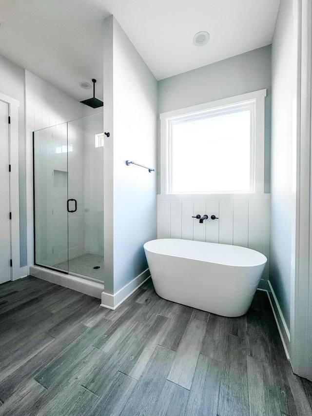 bathroom featuring wood-type flooring and shower with separate bathtub