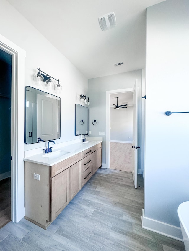 bathroom featuring wood-type flooring, vanity, and ceiling fan