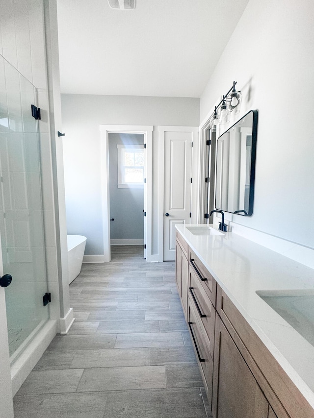 bathroom featuring hardwood / wood-style flooring, vanity, and separate shower and tub