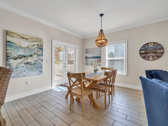 dining area with a notable chandelier, a healthy amount of sunlight, light wood-type flooring, and ornamental molding