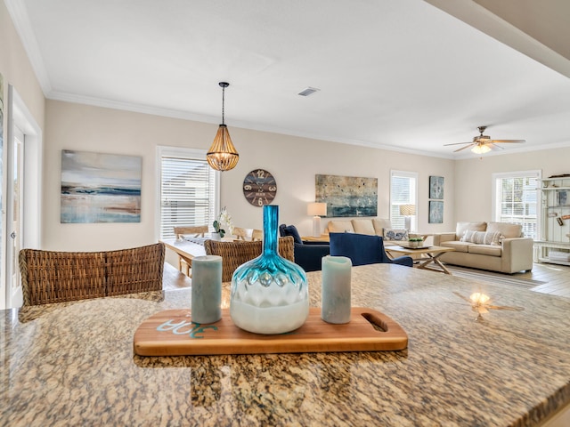 dining space featuring crown molding, wood-type flooring, and ceiling fan with notable chandelier