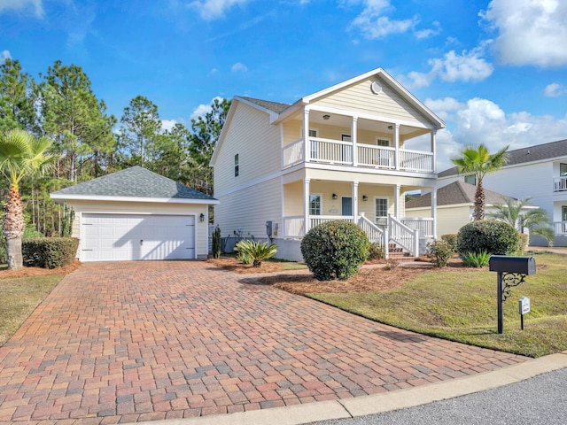 view of front facade with a front yard, a porch, a balcony, and a garage