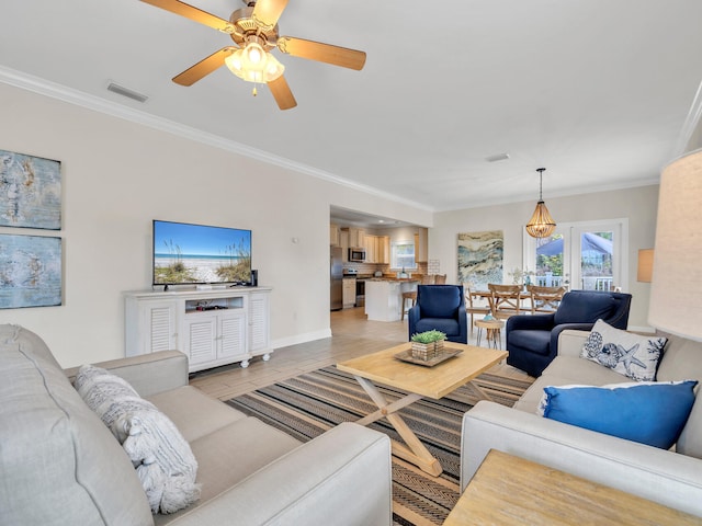 living room featuring crown molding, ceiling fan, and light wood-type flooring