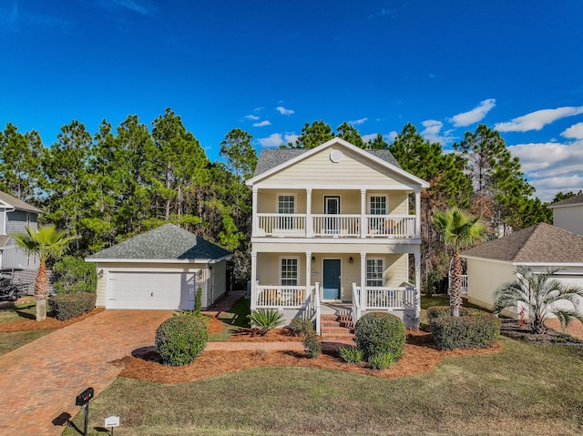 neoclassical home with covered porch, a garage, an outdoor structure, and a front yard