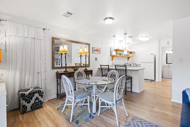 dining space with light wood-type flooring