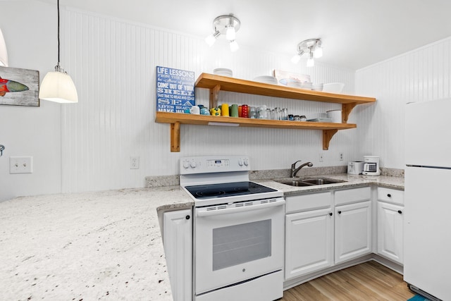 kitchen with sink, white appliances, white cabinetry, and light stone counters