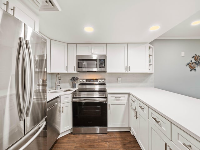 kitchen featuring backsplash, dark wood-type flooring, sink, appliances with stainless steel finishes, and white cabinetry