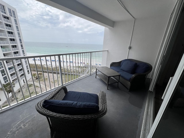 balcony with a water view and a view of the beach