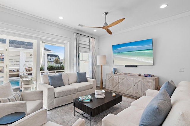 living room with ceiling fan and crown molding